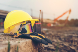 Construction helmet underneath radio and goggles. We handle personal injury and construction disputes.