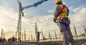 Construction worker looking at general contractors and a crane in Boise, ID. Our super lawyers deal with legal issues surrounding construction contracts.