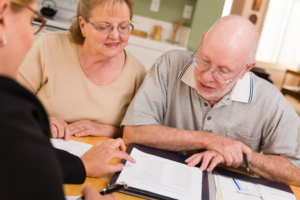 a lawyer gives advice an elderly couple about their estate and money.