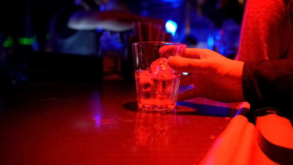 person holding an alcoholic beverage at a bar