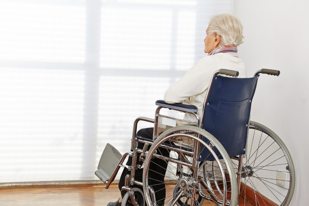elderly woman in wheelchair looking out the window